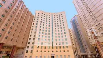 Un hôtel à plusieurs étages, doté d’une entrée centrale, de nombreuses fenêtres et d’une architecture moderne.