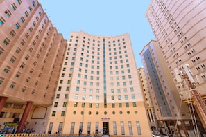 A multi-story hotel with a central entrance, numerous windows, and a modern architectural design. - ADDRESS AJYAD HOTEL (Makkah)
