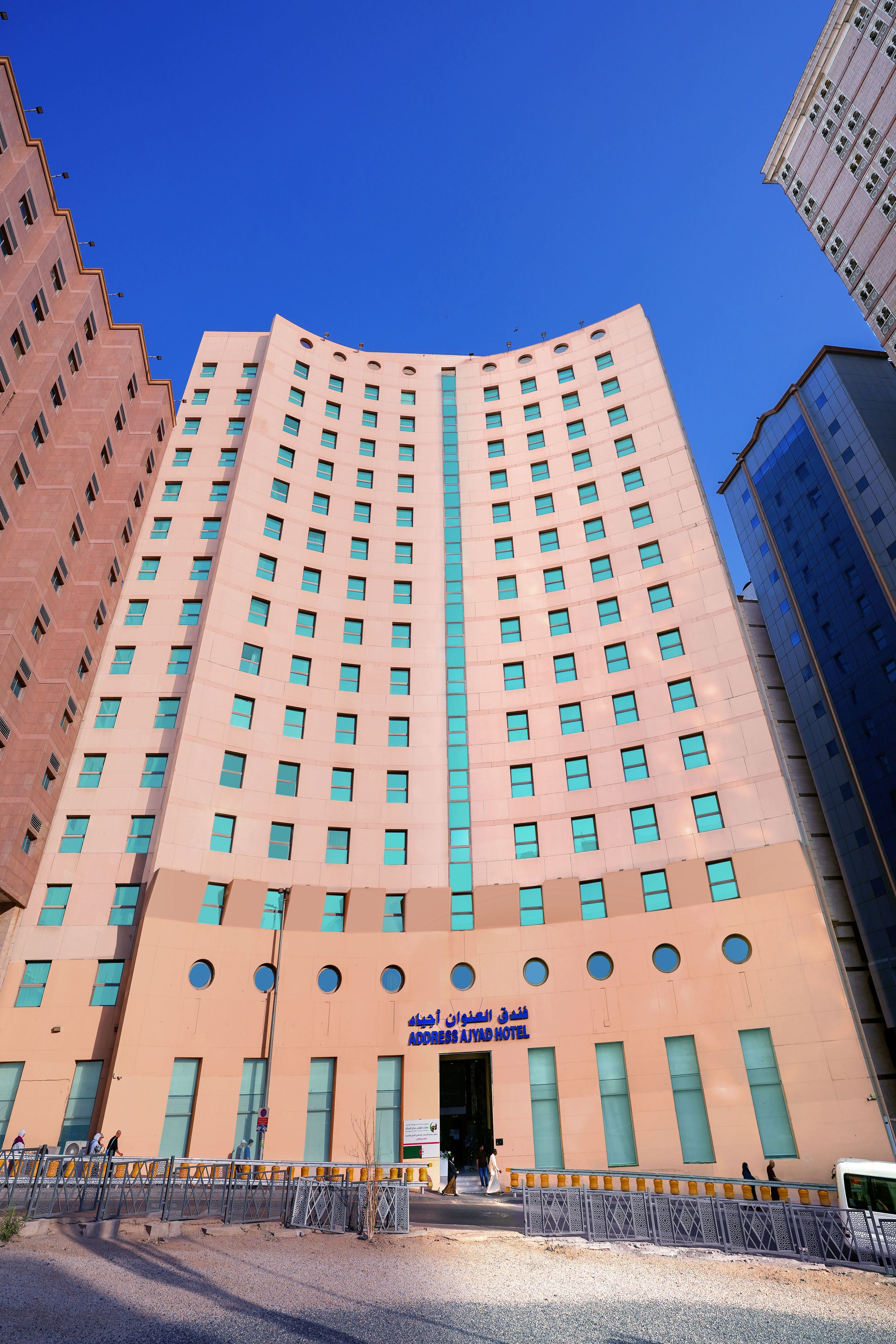 A tall hotel building with a central entrance and multiple windows.