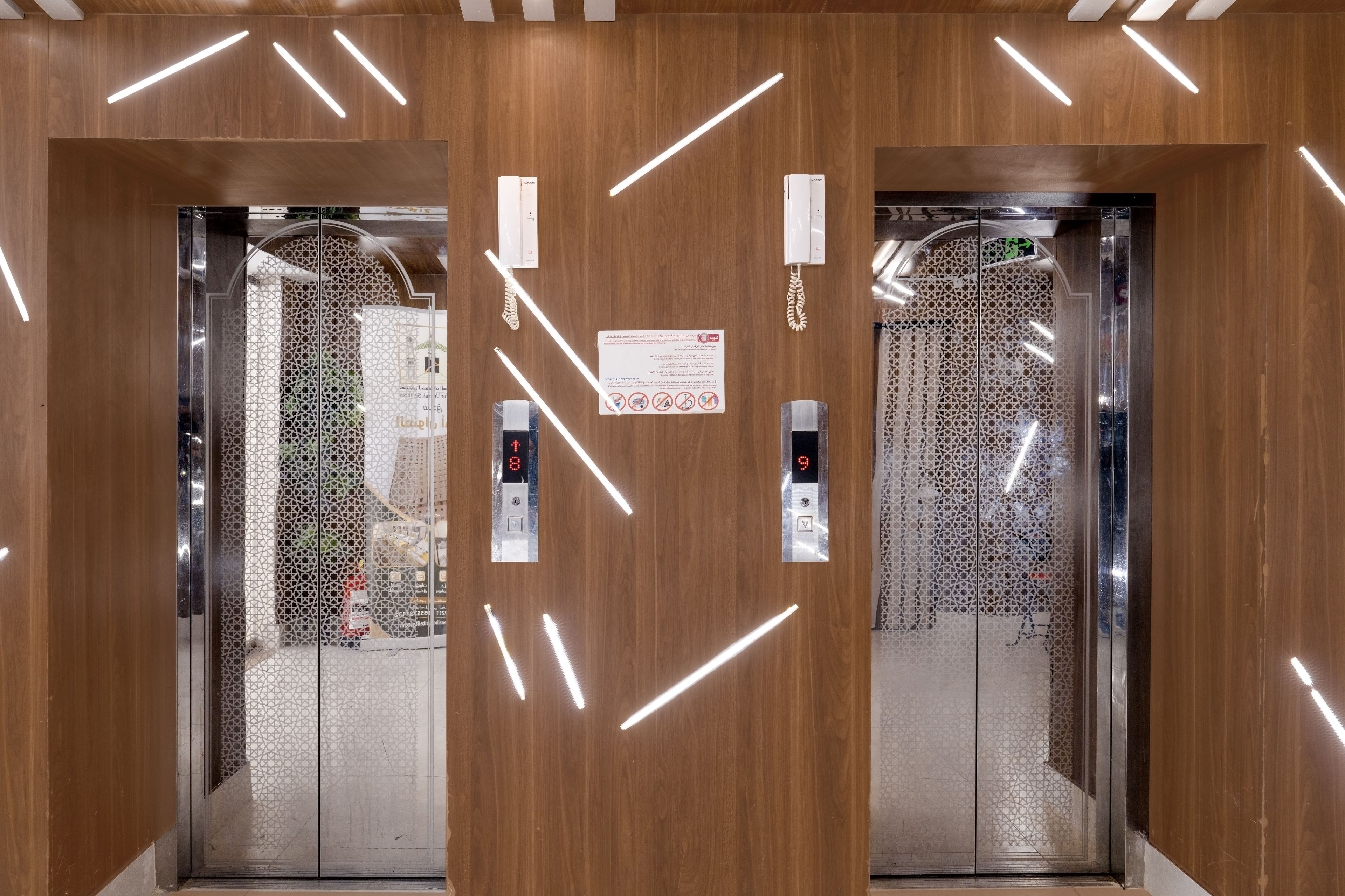 An elevator interior with wooden paneling and modern lighting fixtures.
