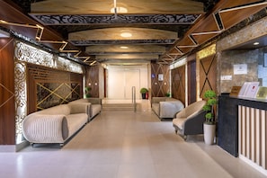 A hotel reception area with a modern design, featuring a reception desk, seating area with sofas, and a decorative ceiling. - ADDRESS AJYAD HOTEL (Makkah)
