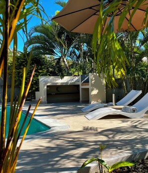 A pool area with lounge chairs and a covered seating area. - The Pearl Villa - With private pool (Petit Raffray)
