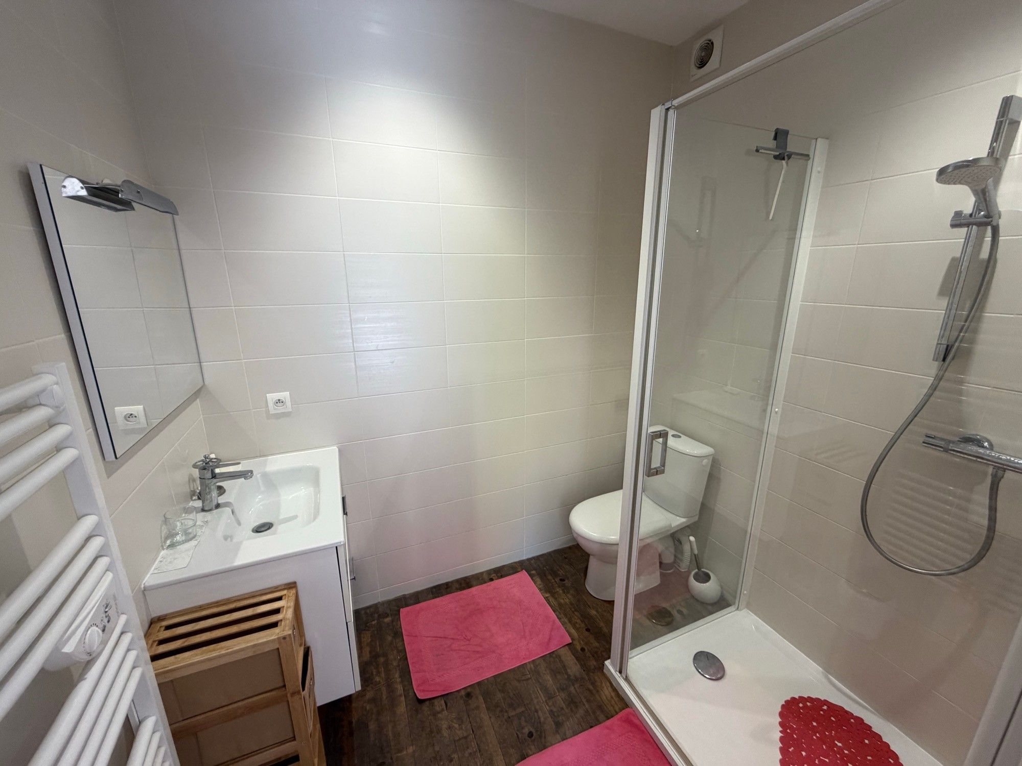 Un bagno con doccia, toilette, lavandino e specchio.