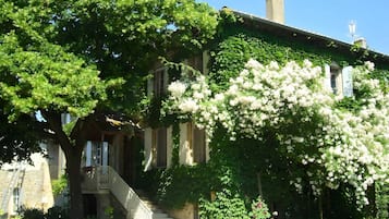 Un bâtiment historique doté d’une façade en pierre, d’un porche couvert et d’un escalier menant à l’entrée.