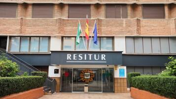 A building with a sign reading 'RESITUR' and multiple flags.