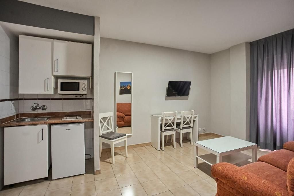 A compact living space with a kitchenette, a dining area, and a seating area.