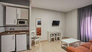 A compact living space with a kitchenette, a dining area, and a seating area.