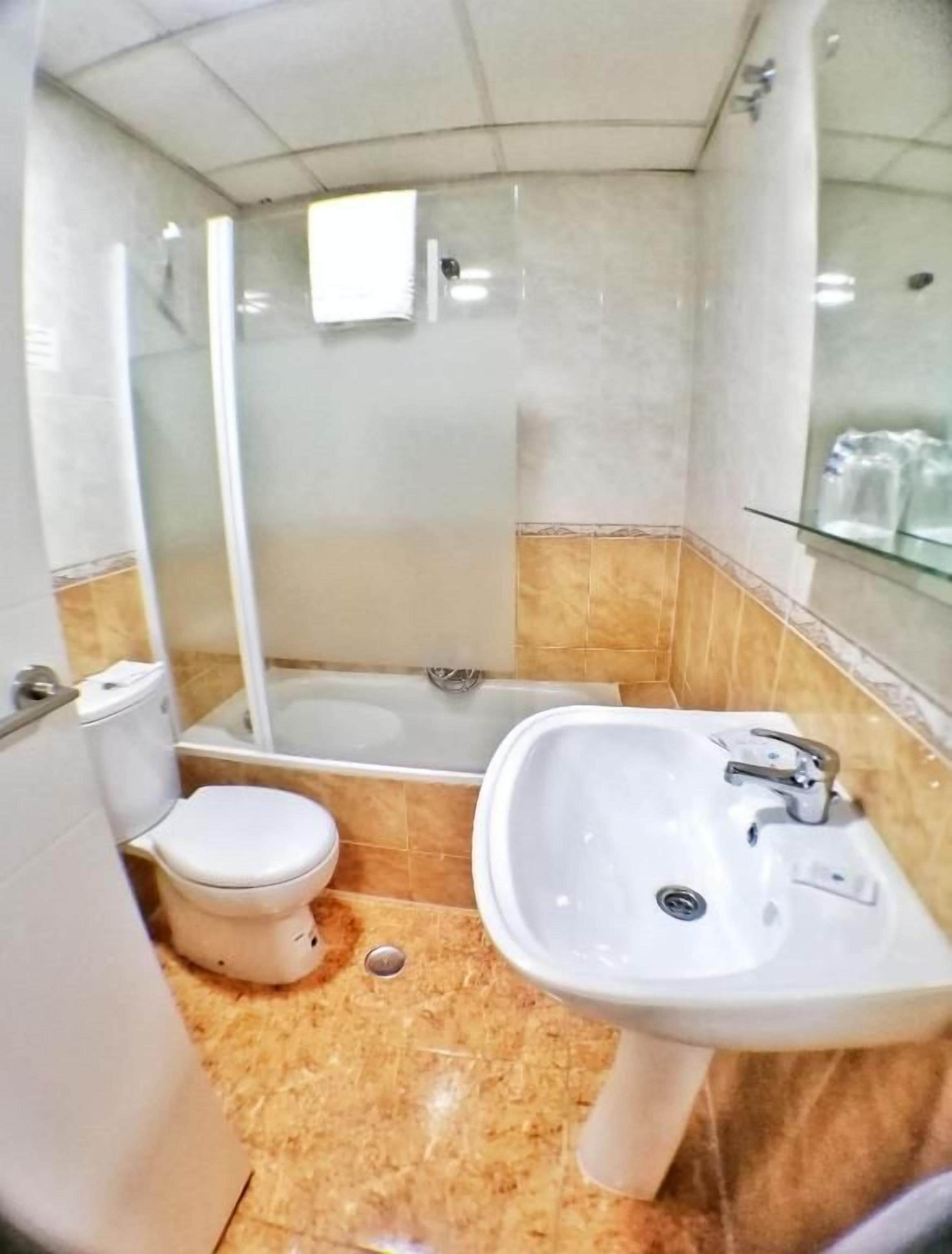 Une salle de bain comprenant des toilettes, un lavabo et un espace douche.