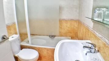 Une salle de bain comprenant des toilettes, un lavabo et un espace douche.