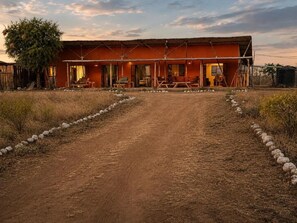 A rustic building with a dirt driveway leading to a covered porch area. - Perfect 3-bedroom house in nice Kajiado County location (Kajiado County)