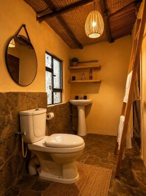 A bathroom with a toilet, sink, mirror, and a hanging light fixture. - Perfect 3-bedroom house in nice Kajiado County location (Kajiado County)