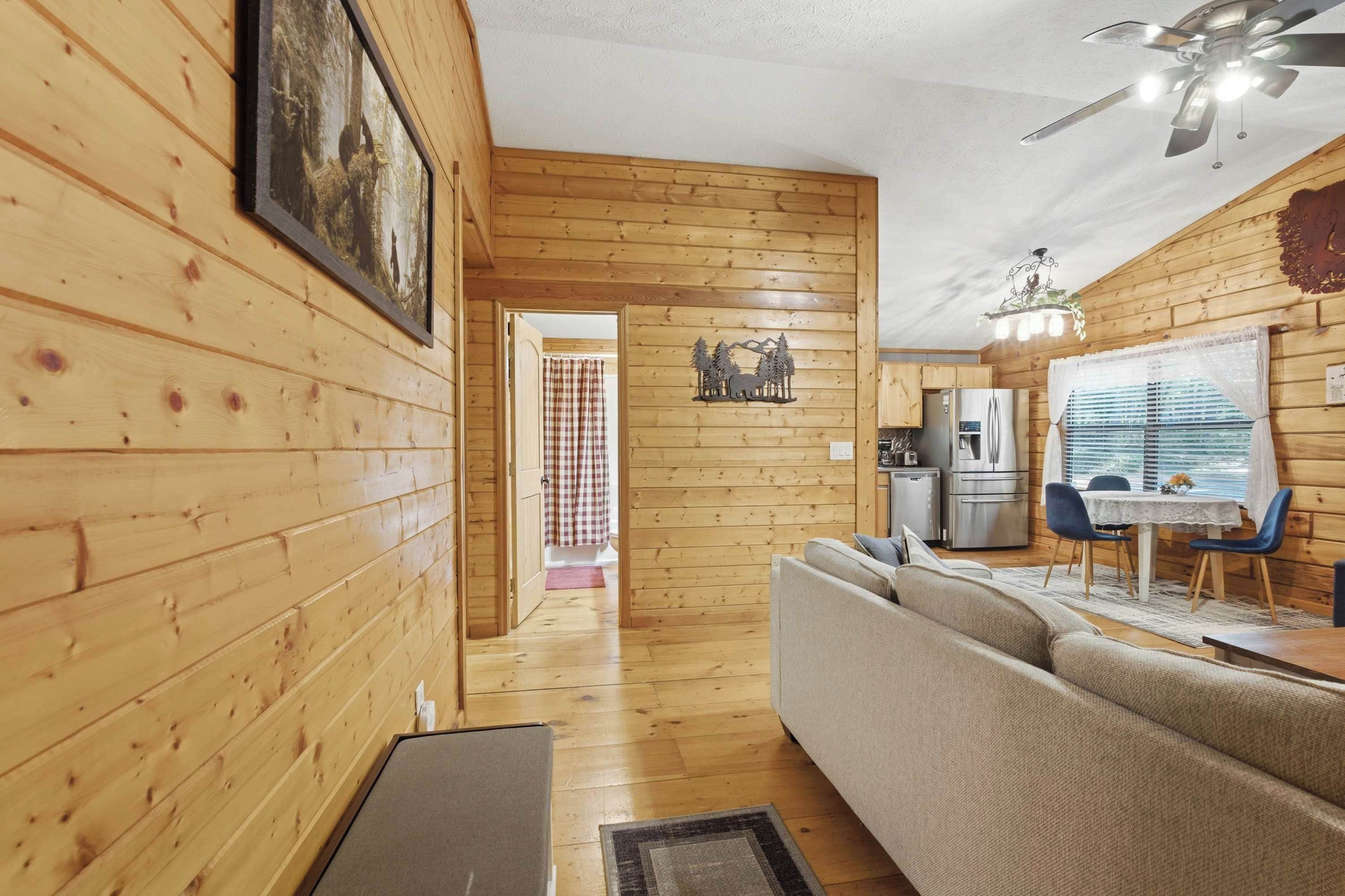 A wooden interior with a sofa, dining table, and kitchen area.