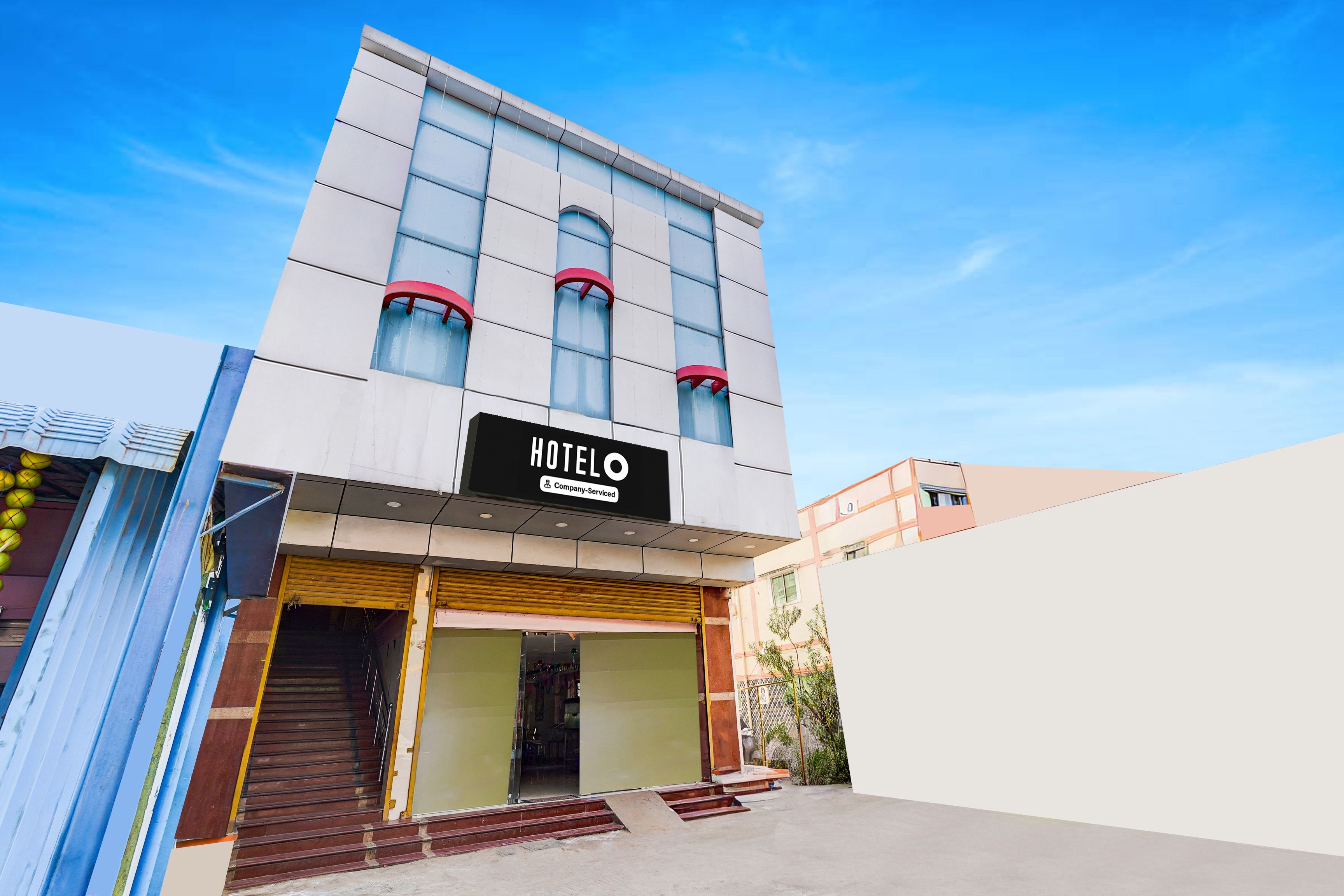 Un hotel anomenat 'HOTELO' amb una façana moderna, una entrada ben visible i un cel serè.