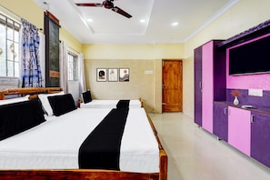 A hotel room with two beds, a ceiling fan, a window with curtains, a door, and a purple wardrobe. - Hotel O Manali Crossway Chennai (Chennai)