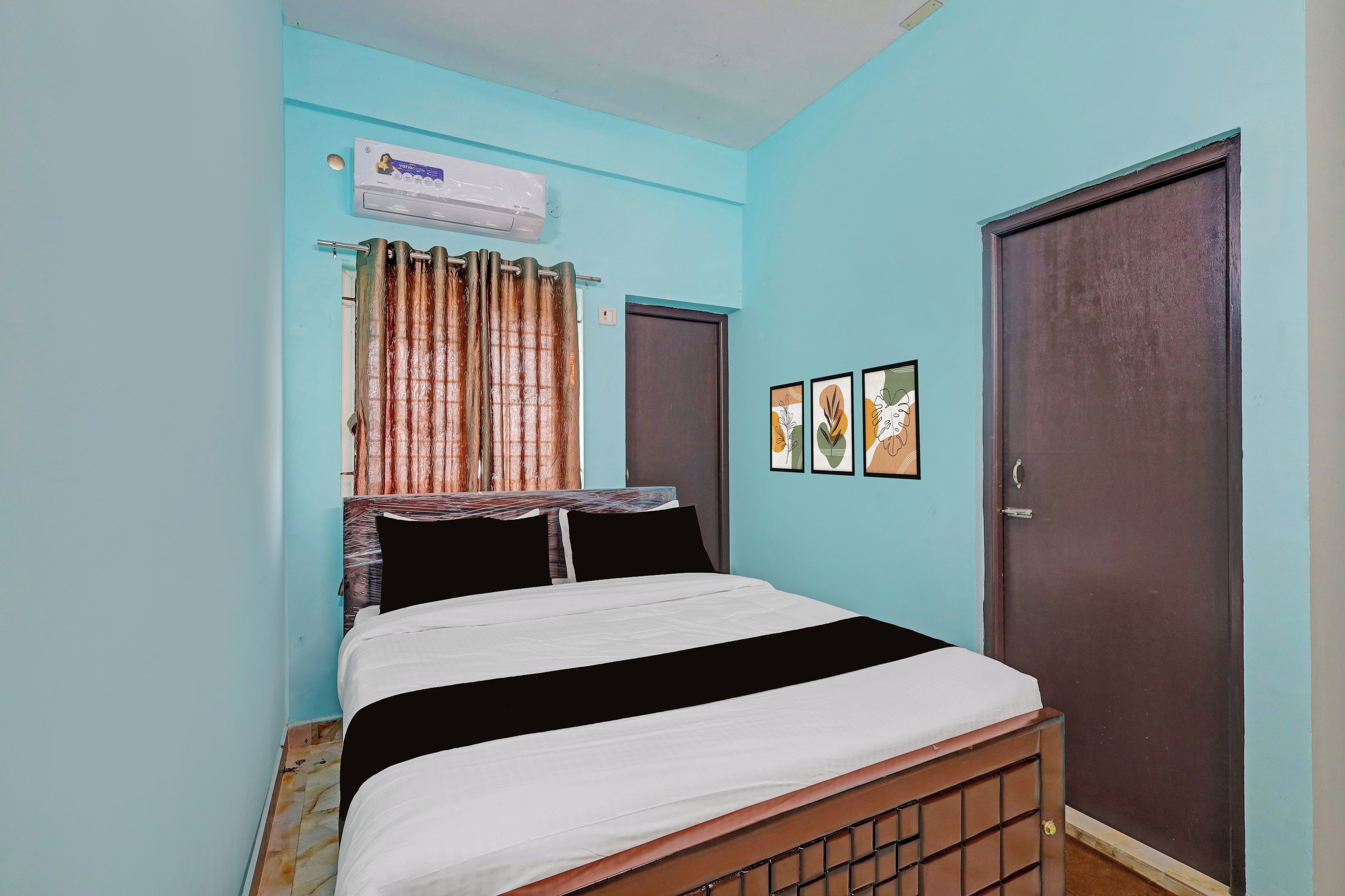 Un dormitorio con cama, ventana con cortinas, puerta y una obra de arte en la pared.