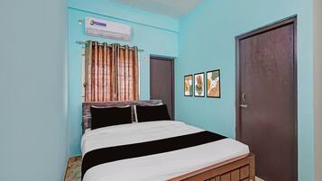 Un dormitorio con cama, ventana con cortinas, puerta y una obra de arte en la pared.