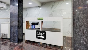 A reception desk with a 'RECEPTION' sign, a 'Collection' sign, and a 'Company-Serviced' label. - Collection O Karumariamman Temple (Chennai)