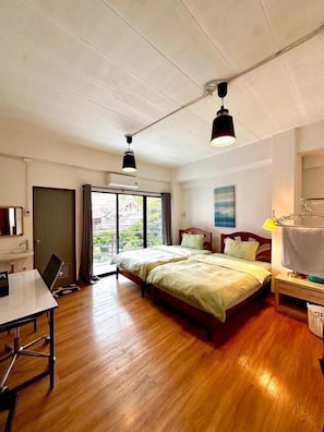 A hotel room with a bed, a desk, and a view through a window. - The Lin Fifty (Klong Toei)
