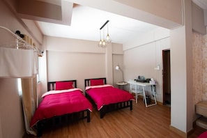 A room with two beds, a desk, and a chair. - The Lin Fifty (Klong Toei)