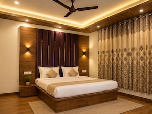 A modern bedroom with a wooden headboard, a ceiling fan, and patterned curtains. - Saima Luxury (Srinagar)
