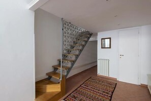 Eine Treppe mit Metallgeländer und Holzstufen, die zu einer weißen Tür führt.