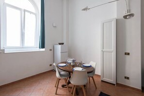 Ein Essbereich mit einem runden Tisch, Stühlen und einem fenster mit Vorhängen.