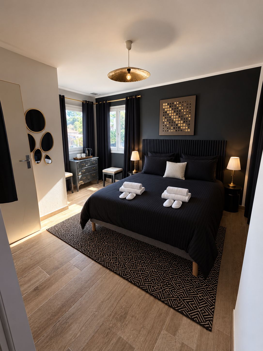 Una habitación de hotel moderna con una cama grande, dos mesitas de noche, un escritorio y una ventana con cortinas.