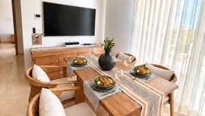 Een moderne eetruimte met een houten tafel gedekt voor twee personen, omringd door rieten stoelen.