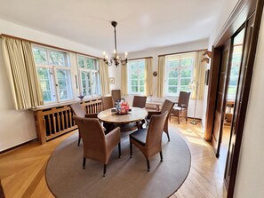 A dining area with a round table, six chairs, and a chandelier. - Großes Fachwerkhaus für 20 Personen bei Hannover, perfekt für Familien + Firmen (Langenhagen)