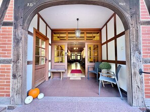 A hallway with a wooden archway, a bench, a chair, and a potted plant. - Großes Fachwerkhaus für 20 Personen bei Hannover, perfekt für Familien + Firmen (Langenhagen)