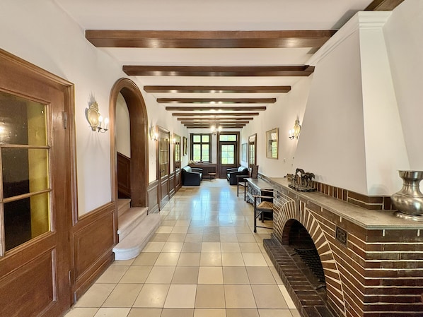 A hallway with a fireplace, wooden beams, and a seating area. - Großes Fachwerkhaus für 20 Personen bei Hannover, perfekt für Familien + Firmen (Langenhagen)