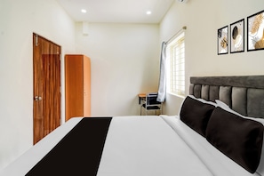 A bedroom with a bed, a wardrobe, a desk, and a window. - Townhouse Oak Hyderabad Victoria (Hyderabad)