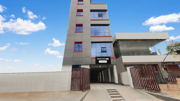 Een meerhoog gebouw met een vlakke gevel, een bedrijfsbord en een hekwerkentree.