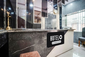 A hotel reception desk with a sign indicating it is company-serviced. - Super Hotel O Mall Road Gwalior (Gwalior)