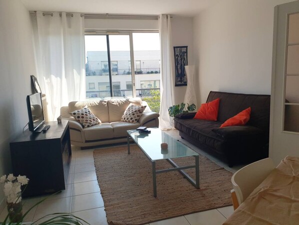 A living room with a sofa, a coffee table, and a TV stand.
