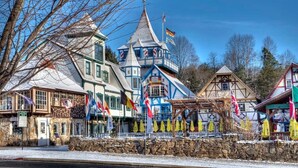 Un bâtiment de style européen traditionnel, orné de plusieurs drapeaux, doté d’une façade en pierre et d’une tour distinctive.