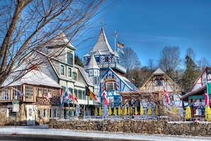 A traditional European-style building with multiple flags, a stone facade, and a distinct tower. - 🌷 Das Tulip of Helen. Center of town, Ground floo (Helen)
