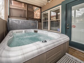 A hot tub with a stone wall and a door with a no entry sign. - Das Tulip | Walk to Helen | 2 King Suites, Hot Tub (Helen)