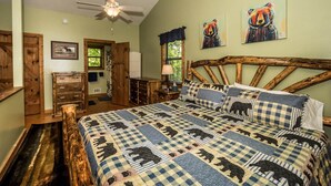 Ein Schlafzimmer mit einem großen Bett, einem Holzkopfteil, einem Deckenventilator und zwei Bildern an der Wand.