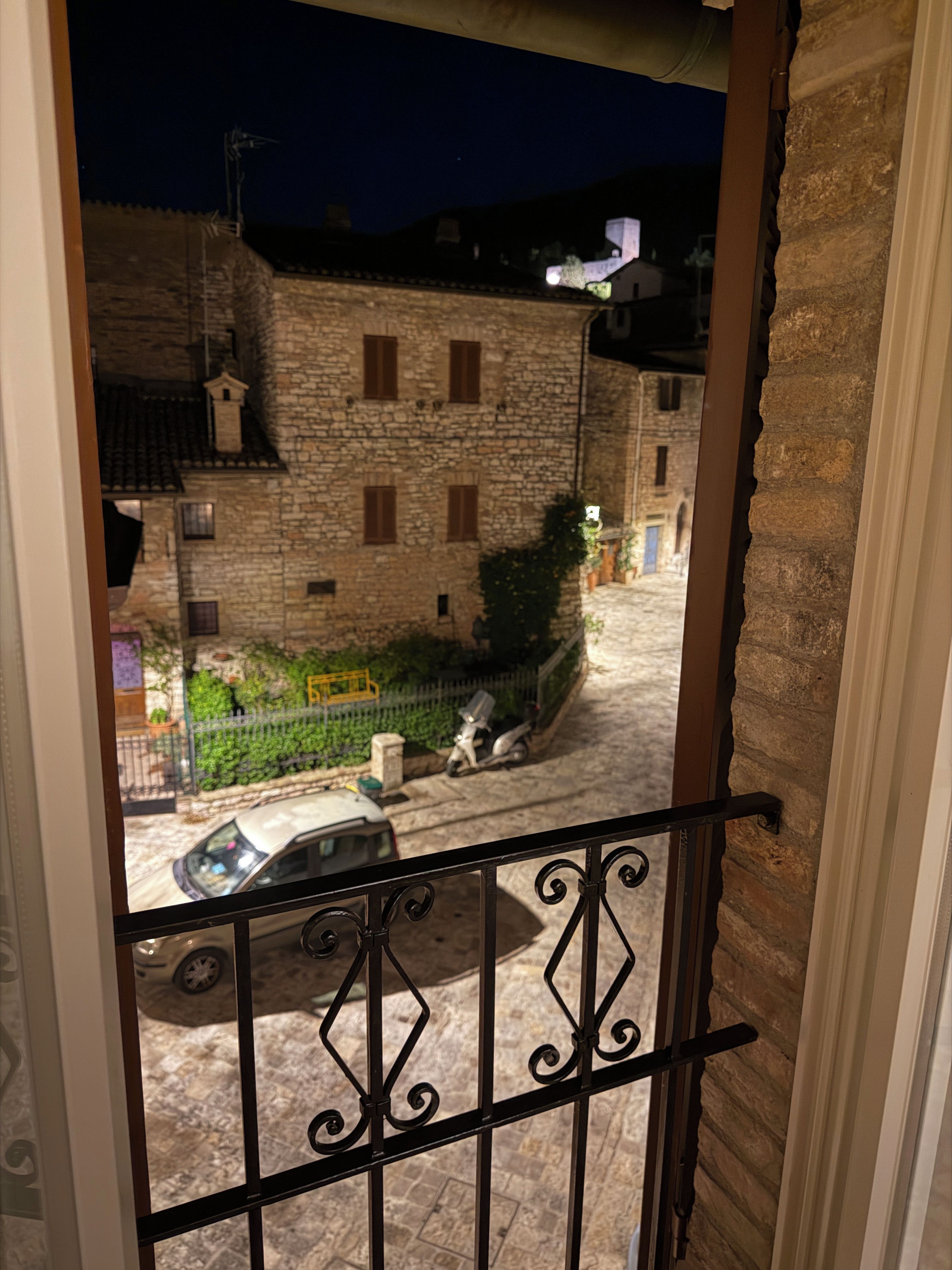 Un edificio in pietra con diverse finestre e una strada lastricata.