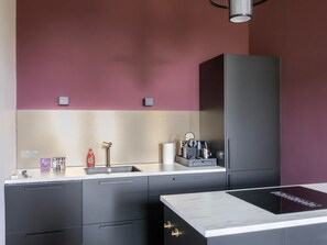 A modern kitchen with a built-in sink, a coffee maker, and a cabinet. - Charming Holiday Home in Kiel-windeweer (Kiel-Windeweer)