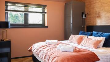 Une chambre à coucher comprenant un lit, une armoire, une table de chevet et une fenêtre avec des stores.