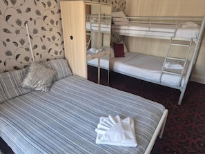 Una habitación con una litera, una cama individual y un armario con espejo.
