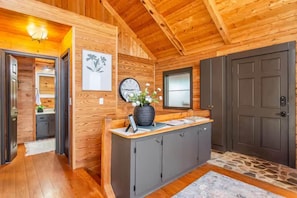 A wooden interior with a reception desk, a clock, and a door. - Licklog Lodge (Ellijay)