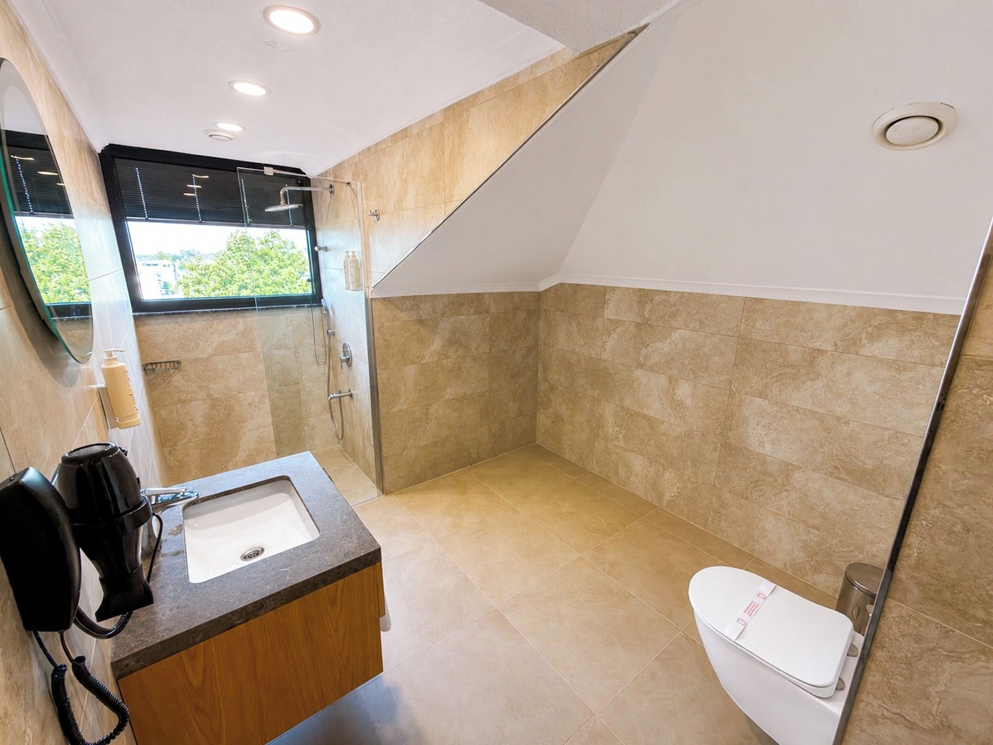 A modern bathroom with a shower, toilet, and sink.