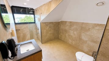A modern bathroom with a shower, toilet, and sink.