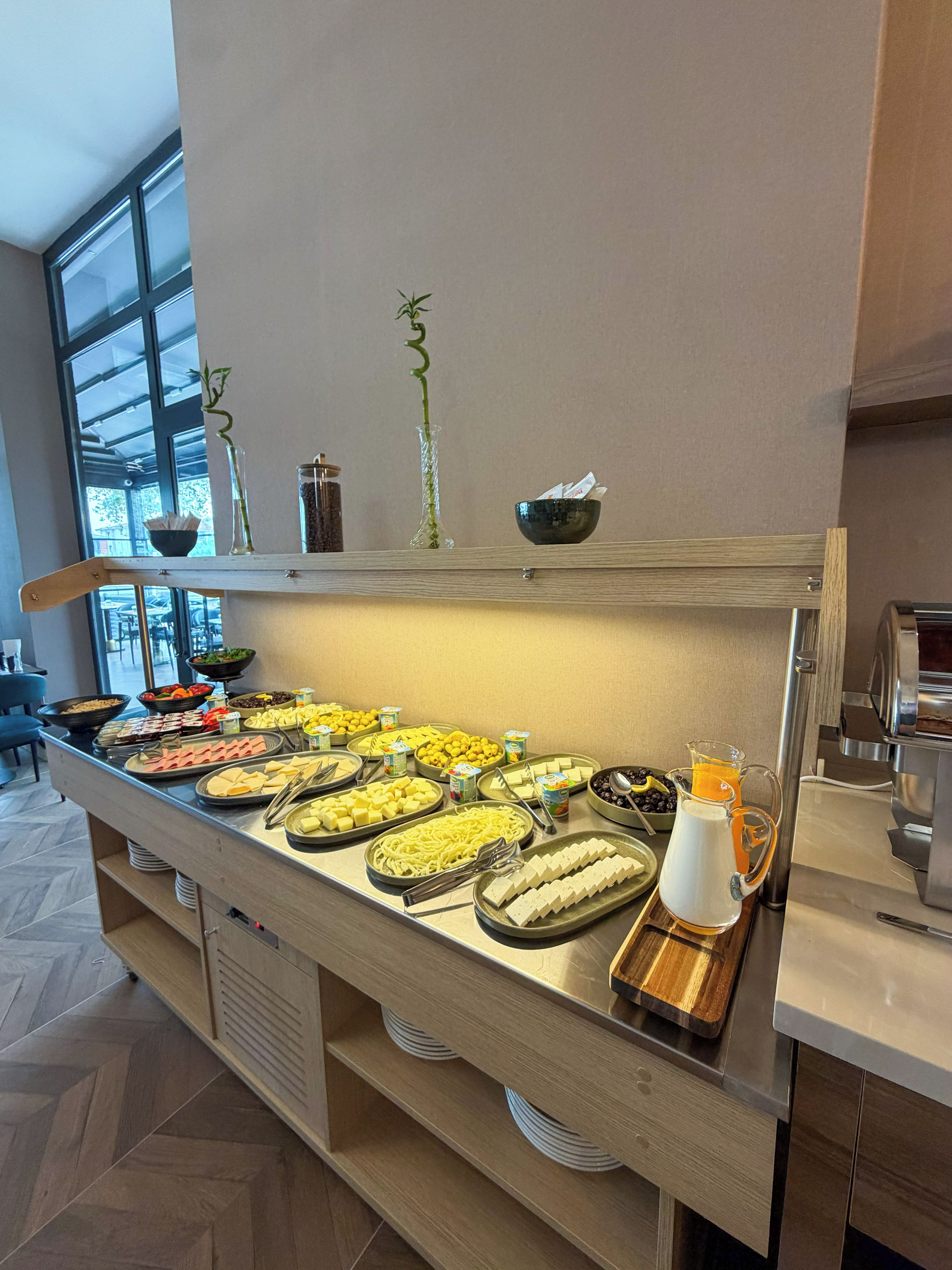 A buffet with various food items and a juice pitcher.