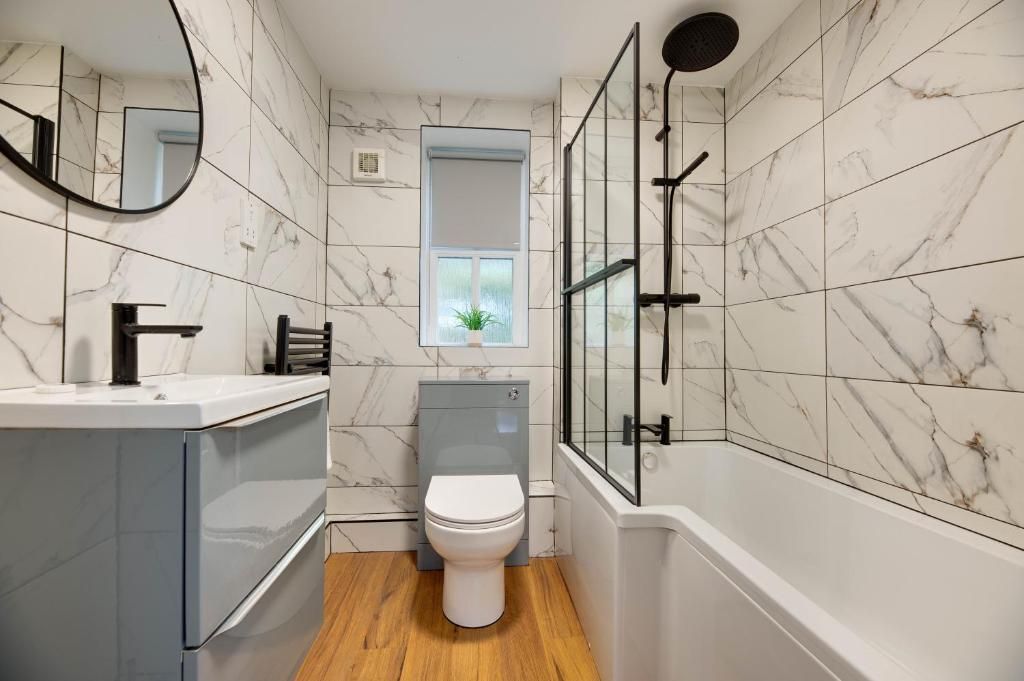 Un baño moderno con inodoro, lavabo y ducha.