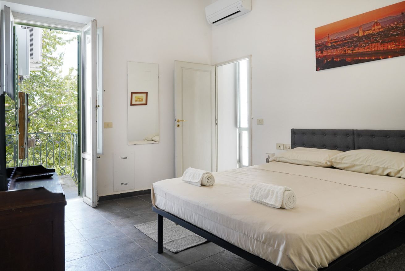 Een slaapkamer met een bed, een bureau en uitzicht op het landschap.