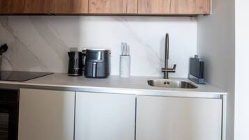 A modern kitchen with wooden cabinets, a stainless steel sink, and a built-in oven.